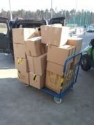 Spakowane kartony z darami na wózku.