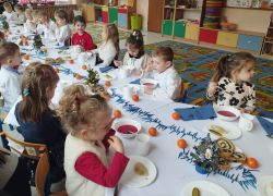 Dzieci przy stole spożywają dania wigilijne