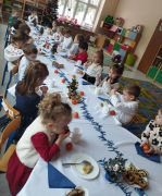 Dzieci przy stole spożywają dania wigilijne